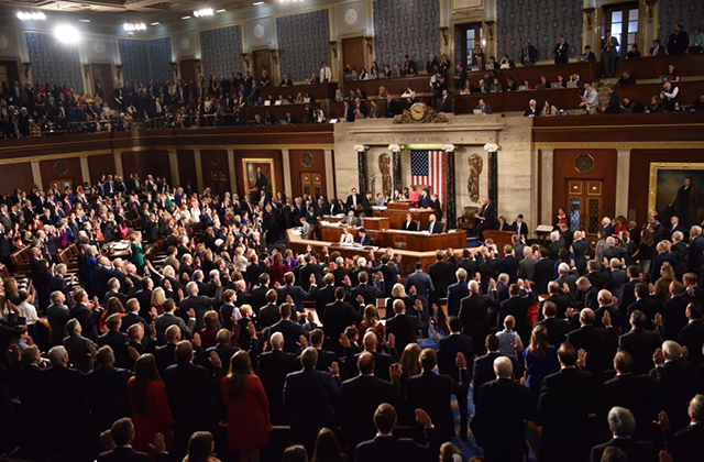 House of Representatives. Shot of the room from above that is crowded with people wearing suits.