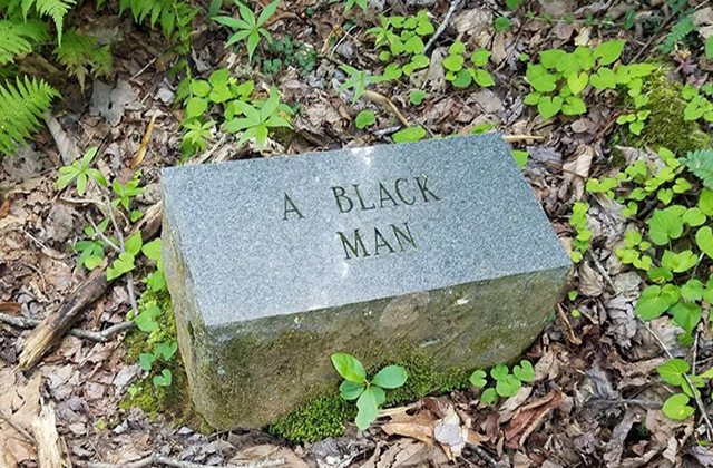 Gray stone in a wooded area with the engraving "A Black Man."