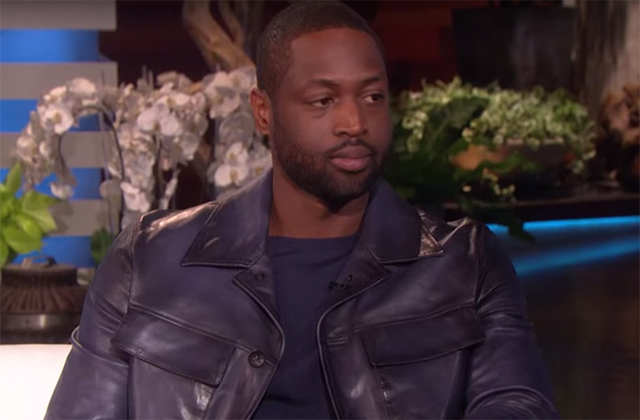 Dwayne Wade. Black man with short dark hair wearing black shirt and black leather jacket on a TV set.