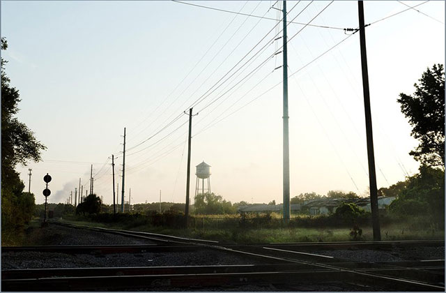 Slave auction site. Rural area with train tracks and power lines.