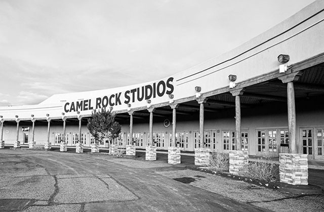 Camel Rock Studios. Black and white image of an open arena with columns and a sign reading "Camel Rock Studios."