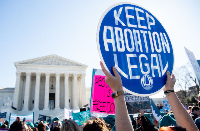Protestor in front of the U.S. Supreme Court holds a sign that reads, "keep abortion legal" 
