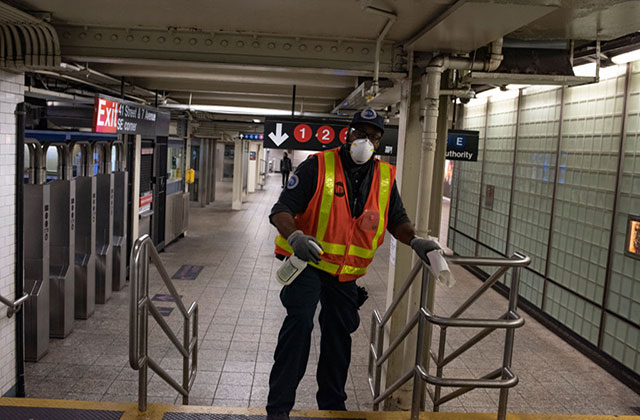 MTA Worker. Man in NYC subway station wearing MTA construction vest, face mask and gloves.