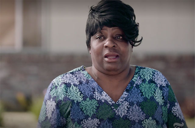 Verna White. Black woman with short dark hair wearing colorful top with flowers.