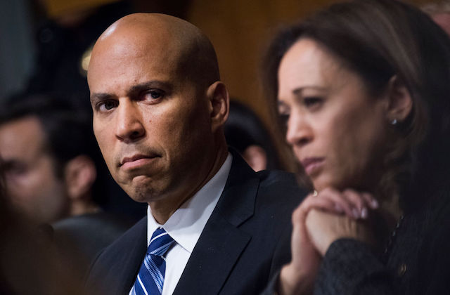 close-up of serious looking senators Cory Booker and Kamala Harris.
