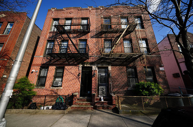 Apartment building. Multi-floor brick building with fire escapes.