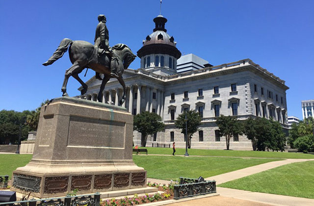 South Carolina. Foreground image of a statue showing man on horse with district court building in the background.