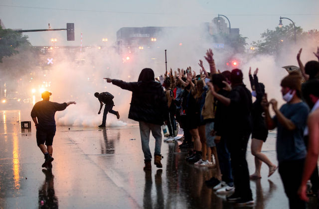 Protestors can be seen against the night sky in a face-off with police officers