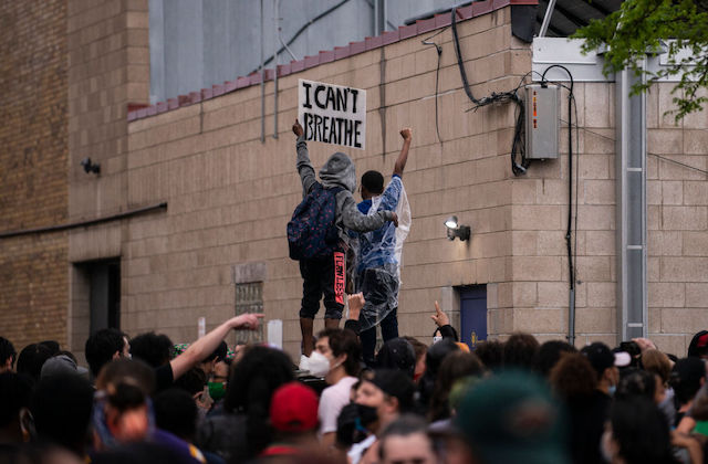 a group protesters wearing face masks hold a sign that reads, "I can't breathe."