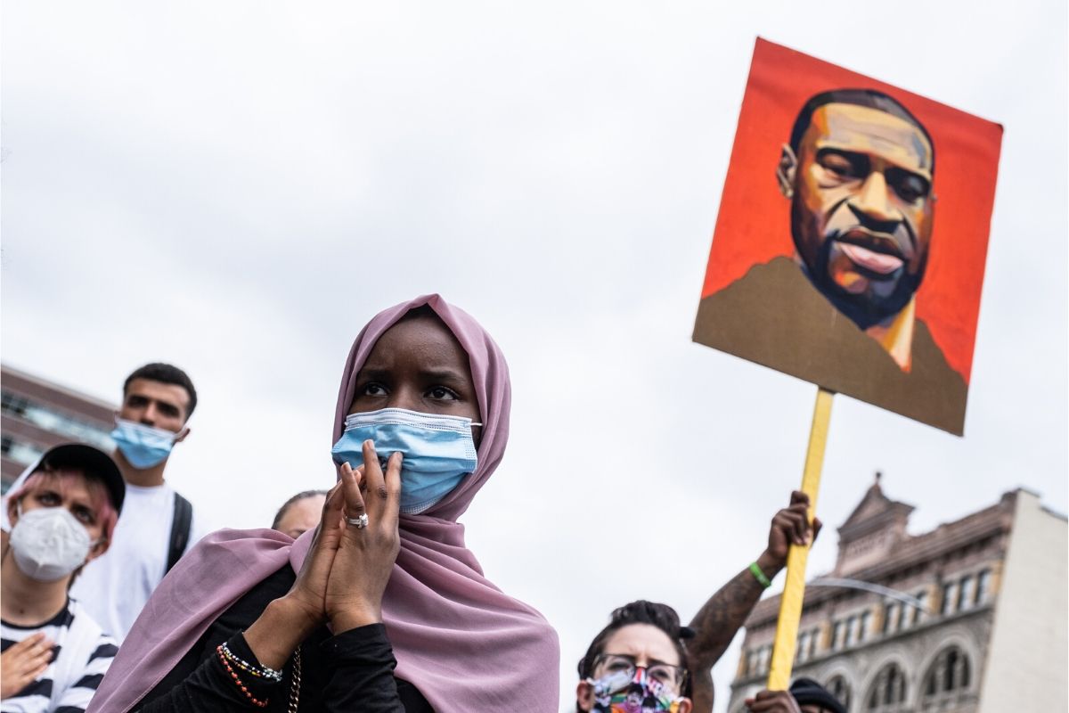 George Floyd Protest. Black Muslima with purple chador, facemask, and others with photo of Geroge Floyd