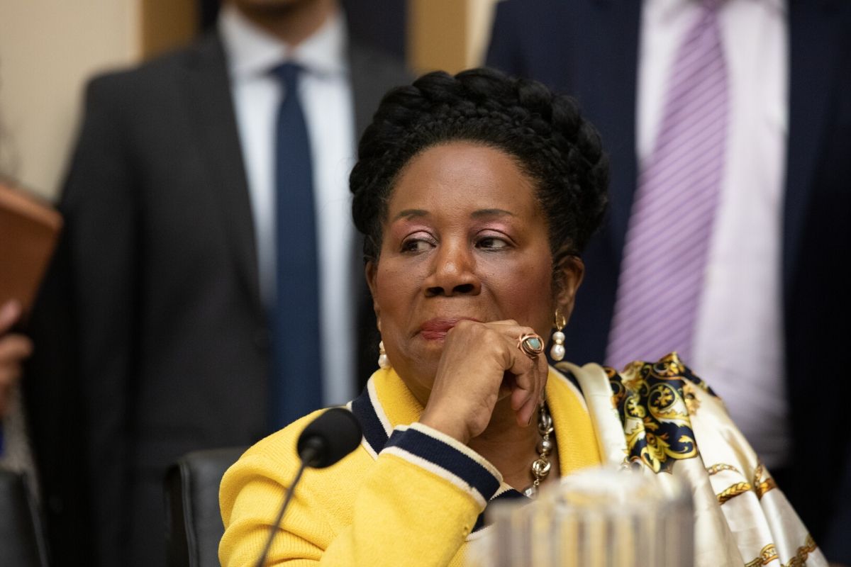 Rep. Sheila Jackson Lee. Striking African American woman with a thick braid crown, yellow jacket and jewelry.