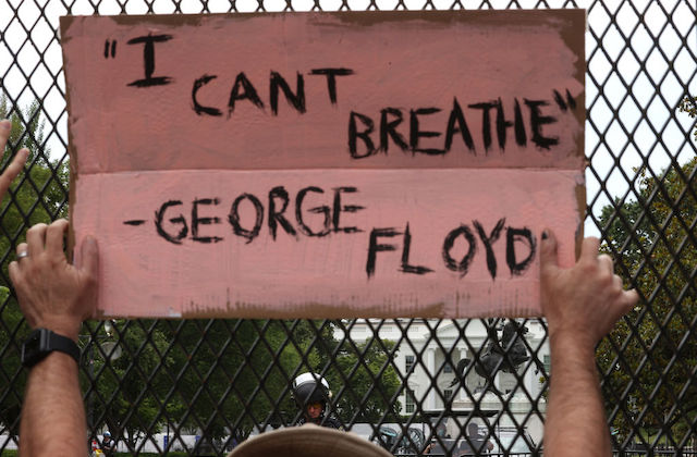 A protestor outside of the White House holds a sign that reads, "I Can't Breathe"