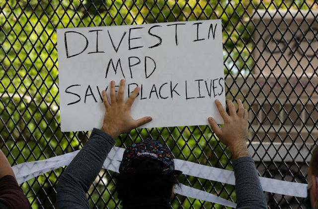 protester hold a sign that reads, "Divest in MPD"