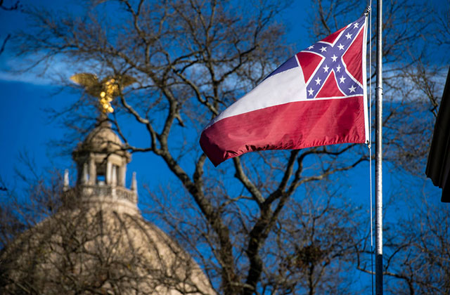 Mississippi Flag. Flag flying in the foreground with the capitol dome in the background.