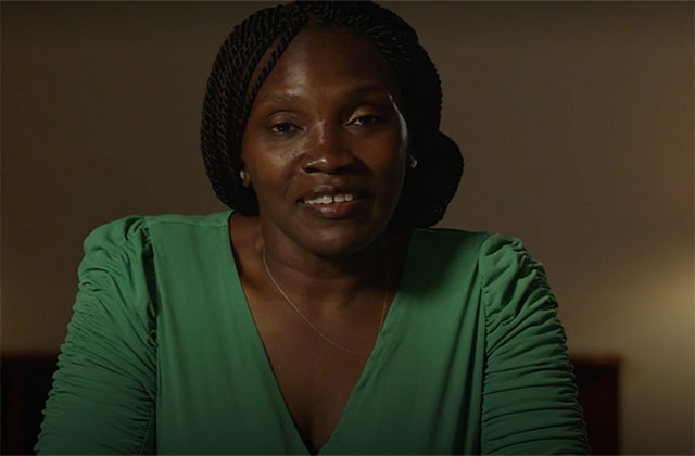 Wanda Cooper Jones. Black woman with long dark braids wearing a green dress.