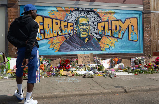George Floyd. A man stands in front of a George Floyd mural in South Minneapolis.