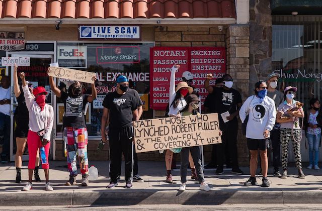 group of protestors holding signs demanding justice for Robert Fuller