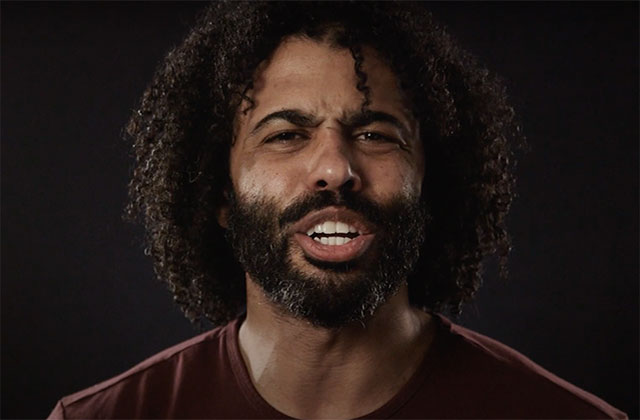 Daveed Diggs. Black man with dark curly hair and dark facial hair wearing a maroon colored top.