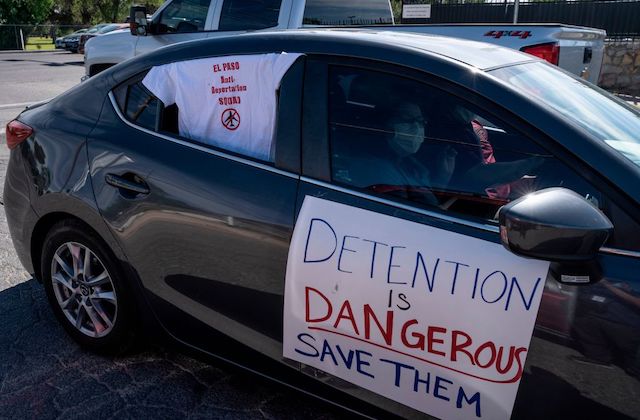 Car with a sign hanging on the side that reads, "Detention is Dangerous."