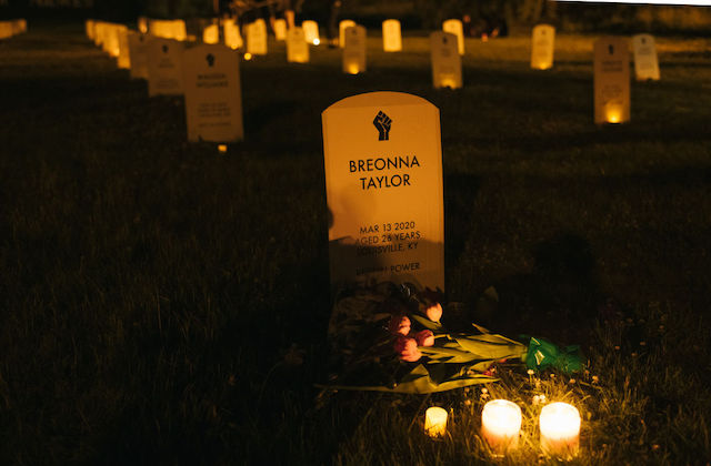A marker surrounded by candles says Breonna Taylor