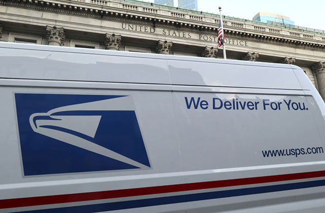 USPS 2020. Side of postal service truck with words "We Deliver For You" in blue letters.