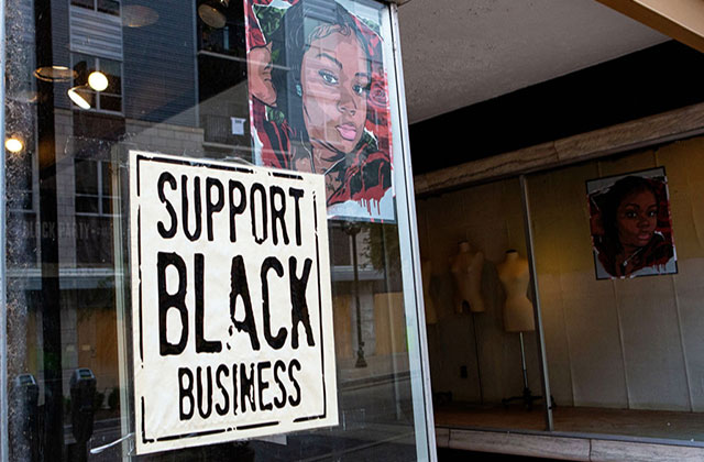 Black Business. Sotrefront with a picture of Breonna Taylor on the window and a sign reading Support Black Business.