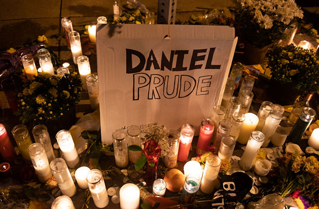 Daniel-Prude-Memorial. Sign reading "Daniel Prude" surrounded by lit candles and flowers.