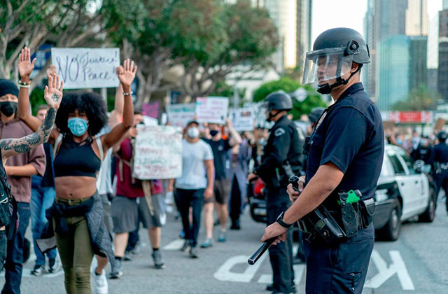 Police Officers. Police officers in line formation as demonstrators march by with signs.