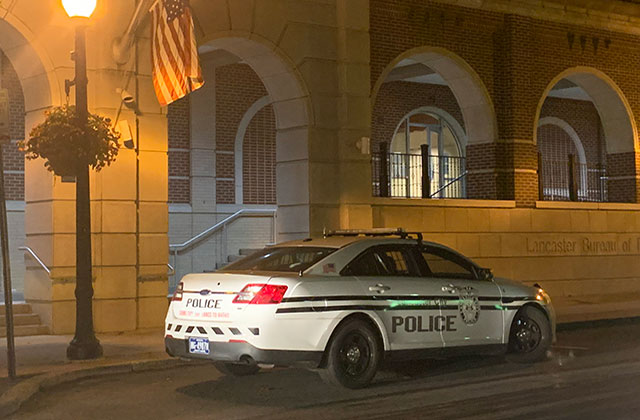 Police cruiser. White car with blue letters.