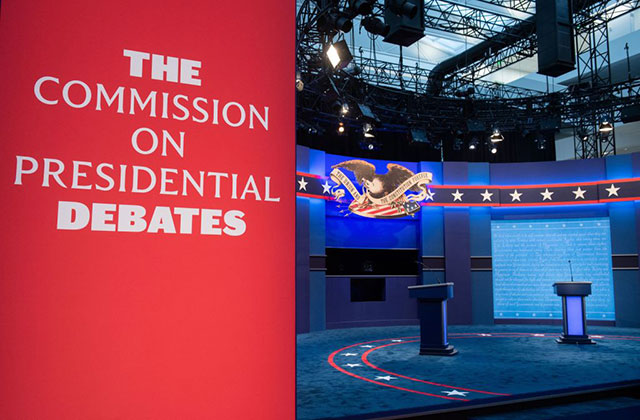 Presidential Debate stage. Red sign reads: The Commission on Presidential Debates. Stage is in the background.