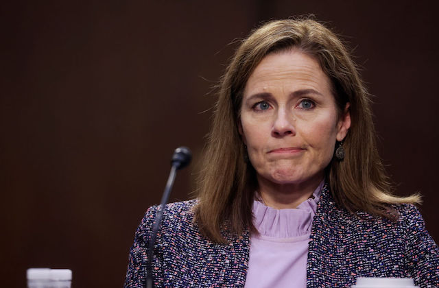 Close-up of older white woman with brown hair and a perplexed look on her face.