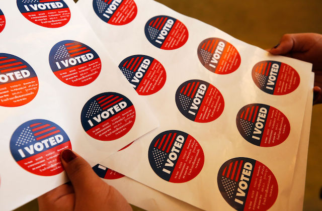 Close-up of several stickers on a white sheet that read, 'I Voted'