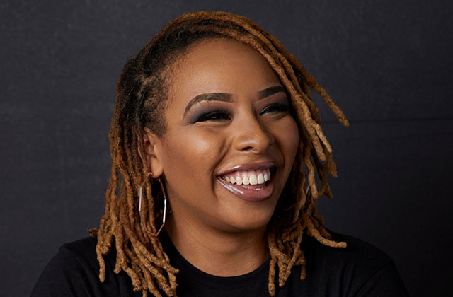Jenae Butler. Black woman with blonde locs wearing a black T-shirt.
