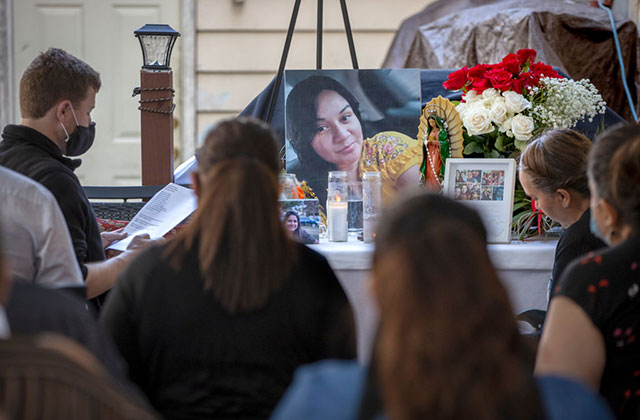 Latinx and COVID. People crowd around a memorial and large photo of Latinx woman.