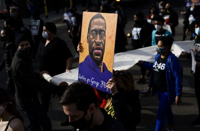 A crowd holds a casket and roses in effigy to George Floyd, who was killed by Minneapolis police in Summer 2020.