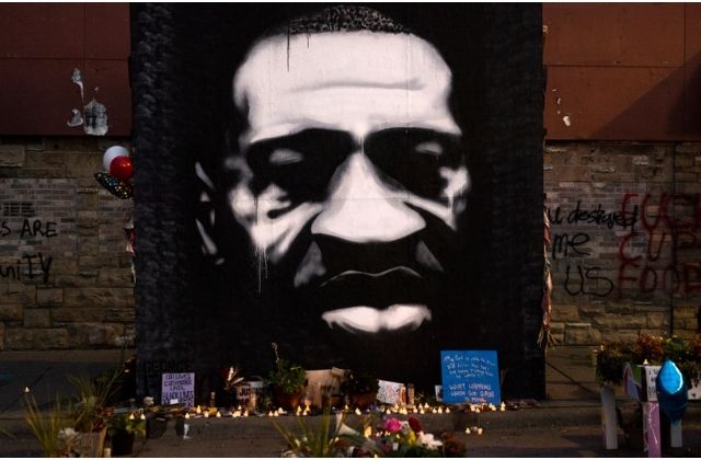 LED candles are placed beneath a portrait of George Floyd during a birthday celebration for him at a memorial site known as "George Floyd Square" on October 14, 2020 in Minneapolis, Minnesota.