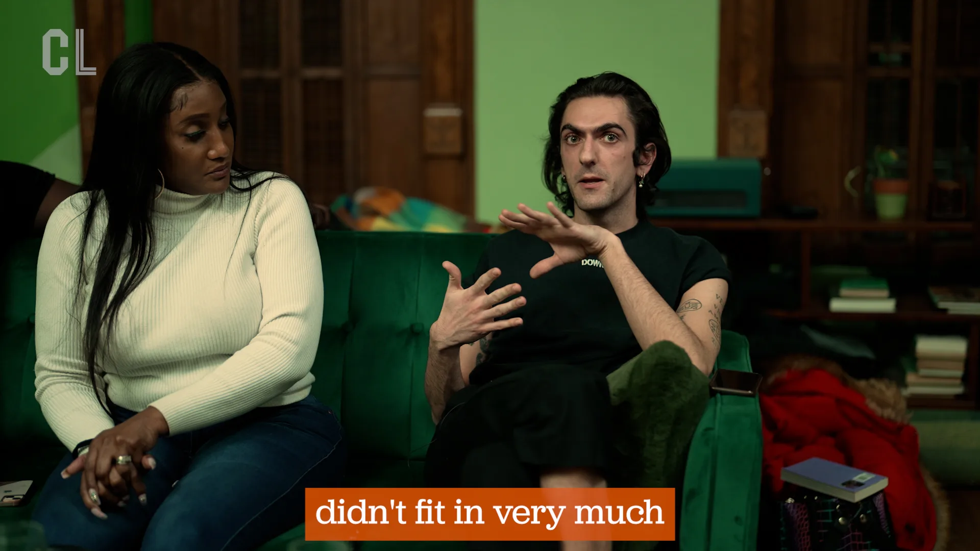 One person watching a second person talking in a green room.