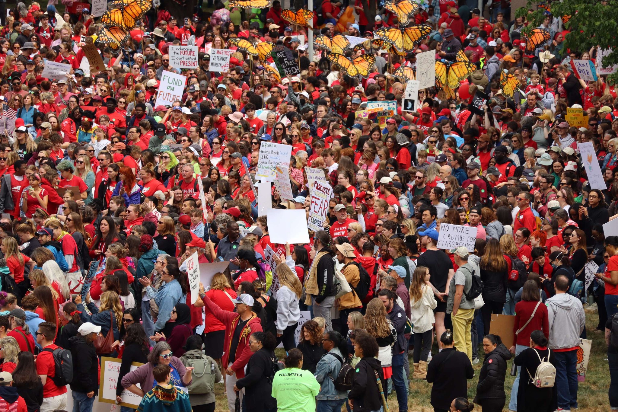 A photo showing protesters wearing mostly read shirts holding up signs