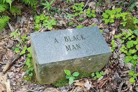 Gray stone in a wooded area with the engraving "A Black Man."