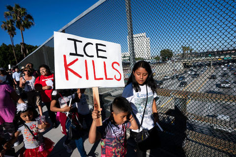 Young boy holds protest sign that reads, "ICE Kills" 