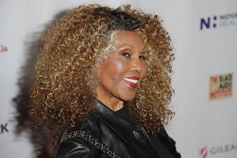 Ja’Net DuBois. Older Black woman, smiling, with long curly blonde hair wearing black top.