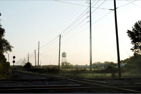 Slave auction site. Rural area with train tracks and power lines.