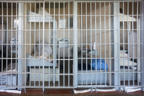 white prison bars inside of a maximum-security prison are shown with signs of the lives inmates are living behind those bars. 
