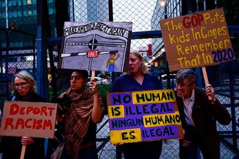 protesters hold signs calling for an end to detaining immigrants 