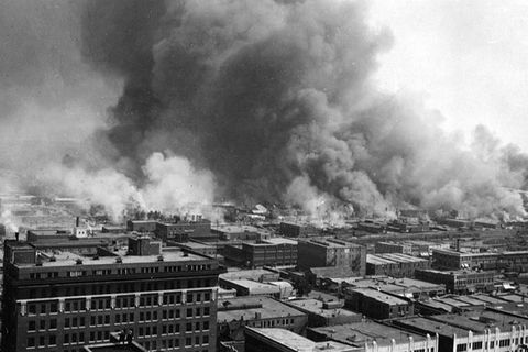 Tulsa Massacre. Black and white photo showing aerial view of buildings on fire and smoke billowing. 
