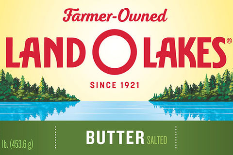 Land-O-Lakes. Packaging for butter that has yellow background with green trees alongside a blue lake.