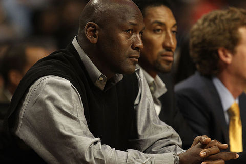 Michael-Jordan and Scottie Pippen. Black man with bald head wearing black vest and gray shirt sitting next to black man with short black hair.