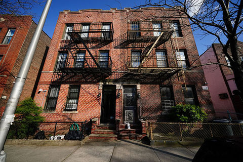 Apartment building. Multi-floor brick building with fire escapes.