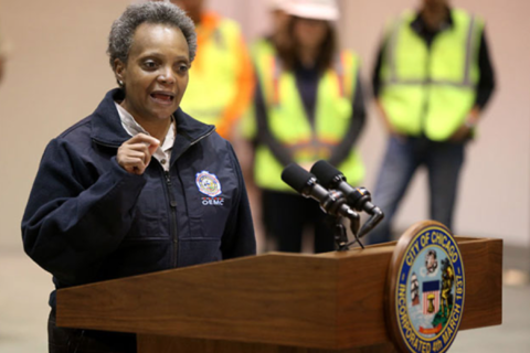 Chicago Mayor Lori Lightfoot. Brown-skinned Black woman with short salt and pepper hair, dressed in a blue windbreaker jacket
