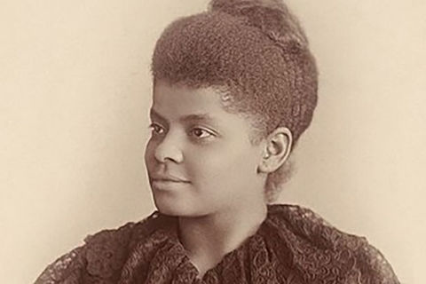 Ida B. Wells. Archival photo of Black woman with hair in top knot, wearing a dark top.